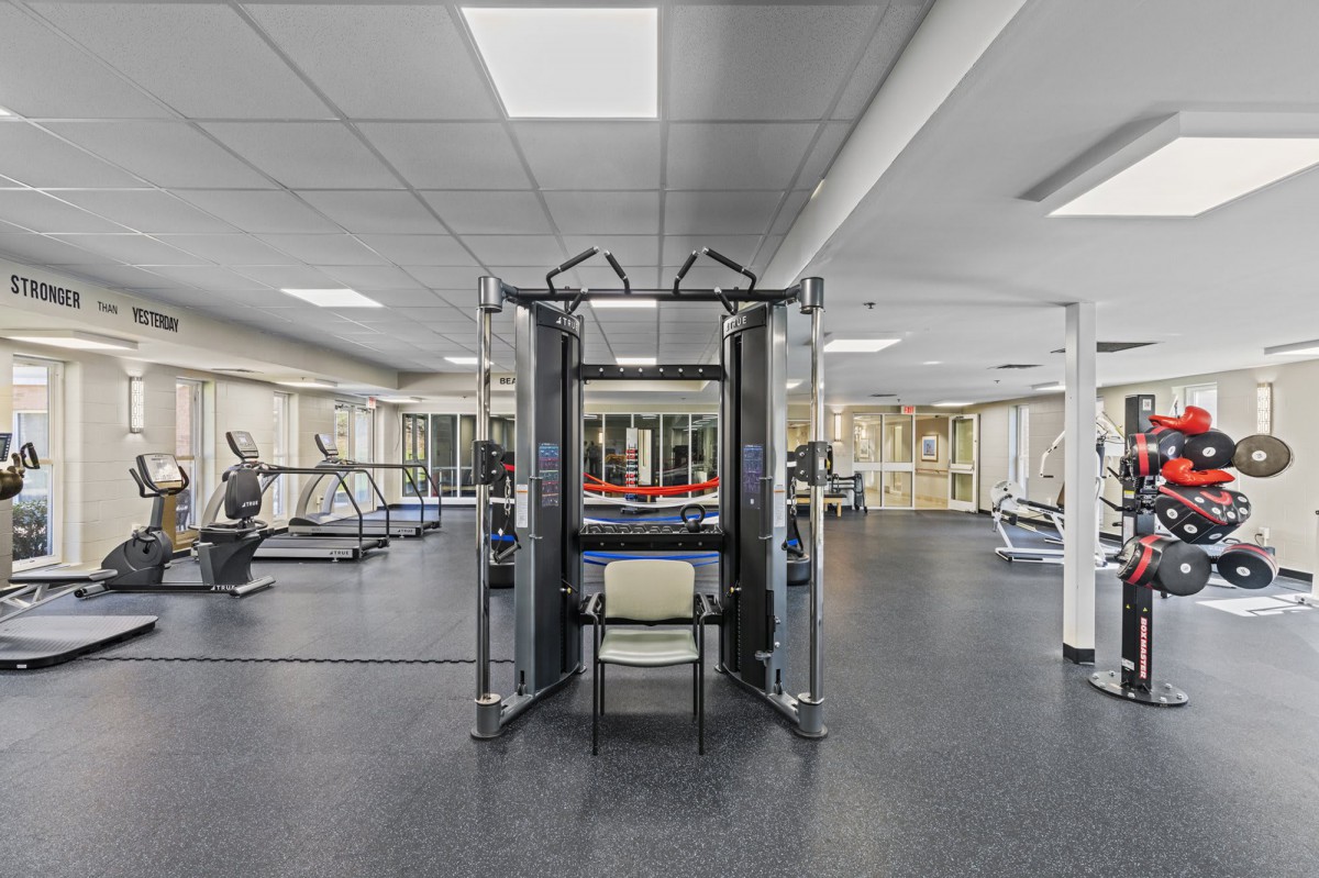 A modern gym with various exercise equipment and machines set up for fitness enthusiasts.