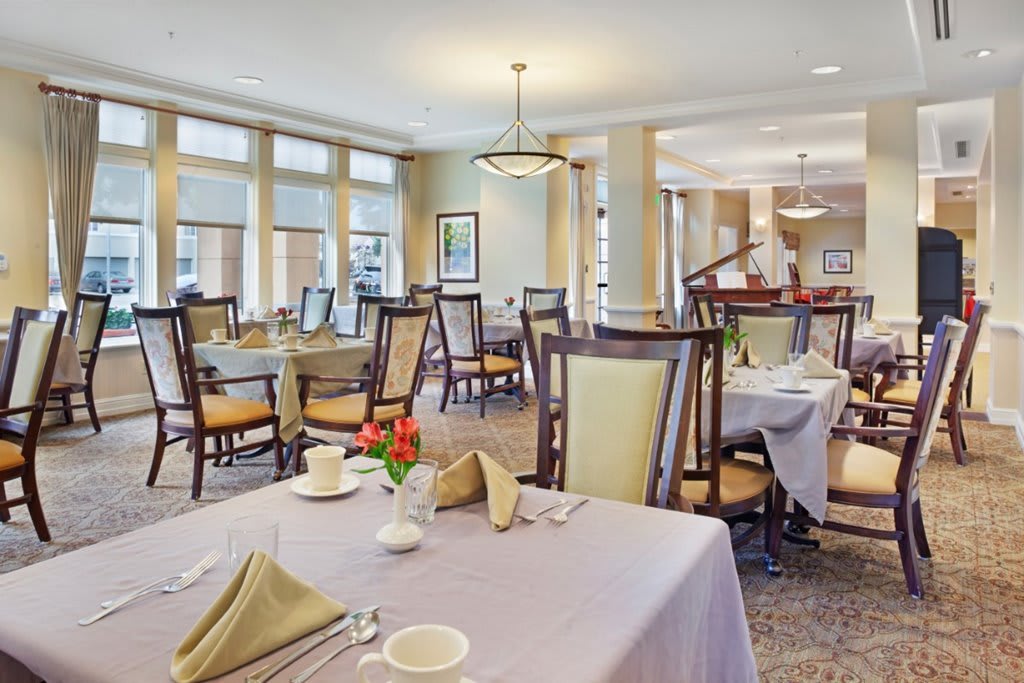 An elegant dining room with neatly arranged tables and chairs, set for a meal.