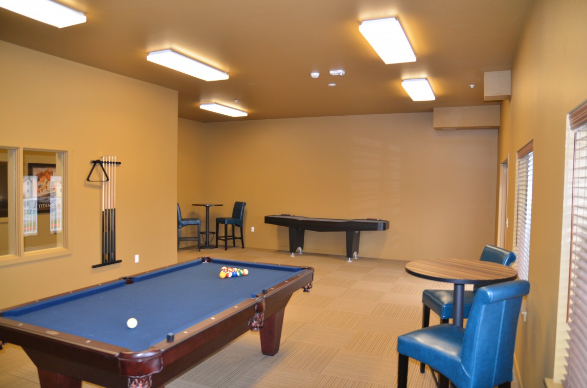 An indoor game room featuring a pool table and an air hockey table.