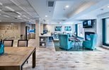 A modern and spacious lobby with comfortable seating and a television.