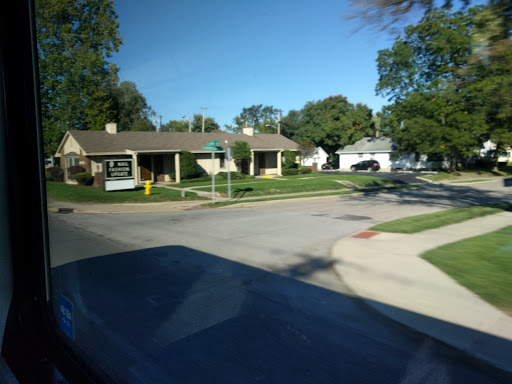 A quiet suburban neighborhood featuring residential homes and clear blue skies.