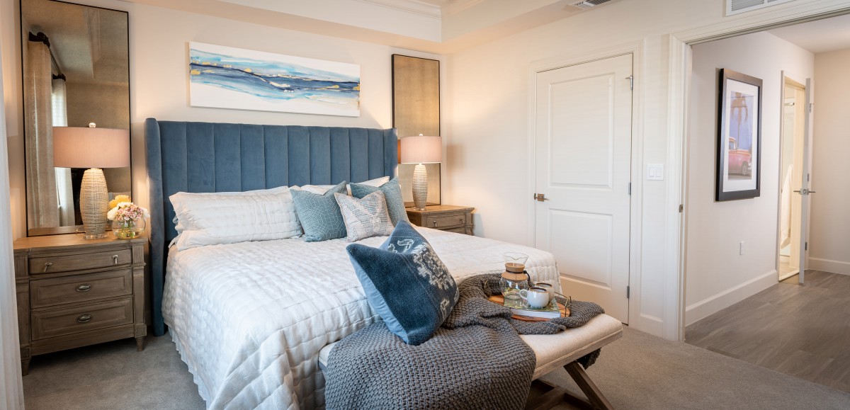 A cozy bedroom with modern decor, featuring blue accents and comfortable bedding.