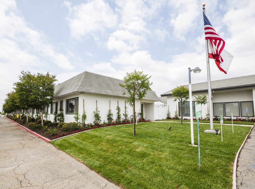 A suburban house with a neatly maintained lawn and an American flag displayed outside.