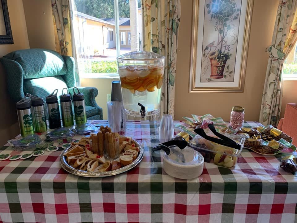 A table set with refreshments including a beverage dispenser, snacks, and drinks for an indoor event.