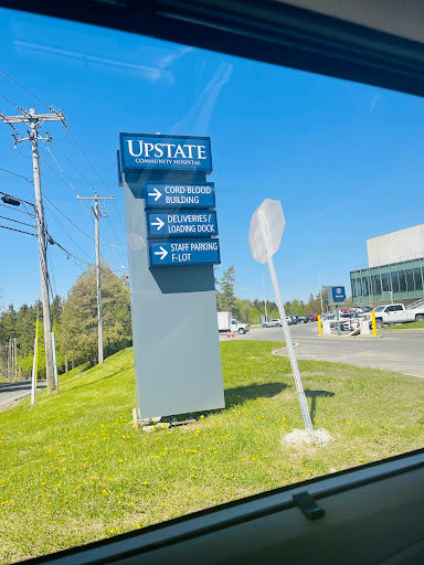 Directional sign for Upstate facilities on a sunny day.