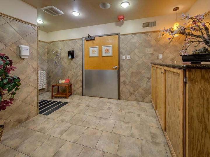 A cozy waiting area with tiled walls and floors, featuring a wooden counter and ceiling lights.