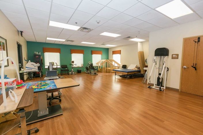 A spacious physical therapy room equipped with various rehabilitation tools and equipment.
