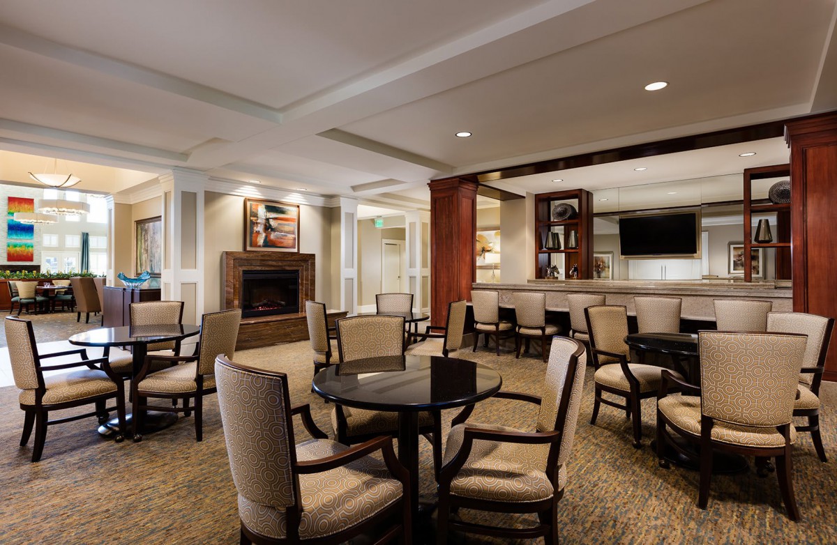 A cozy lounge area with comfortable seating, a fireplace, and a television.