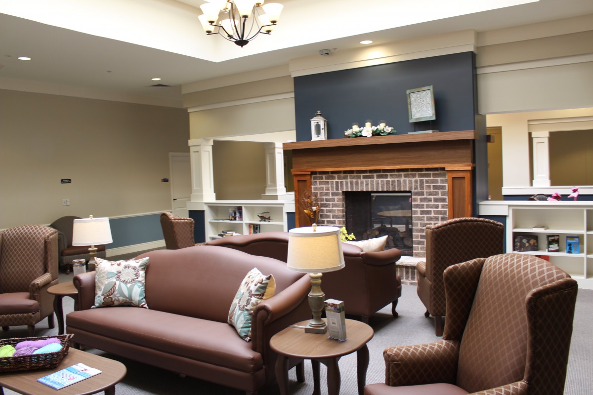A cozy living room with sofas arranged around a brick fireplace, complete with elegant decor.