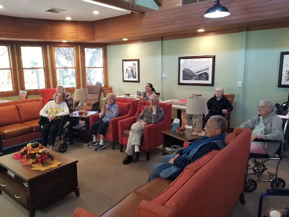 A group of people seated in a room having a discussion.