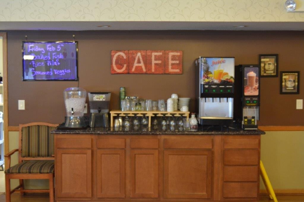 Self-serve cafe area with various drink dispensers and glasses on display.