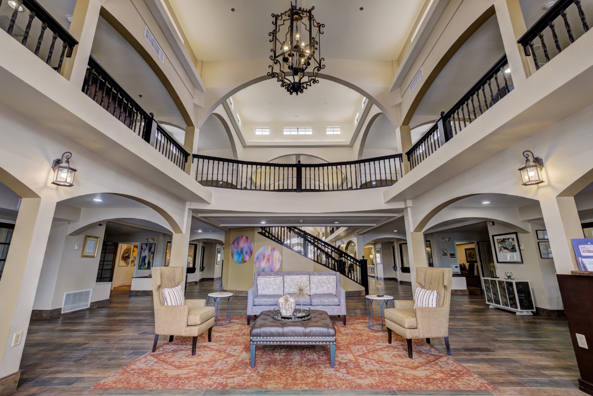 A spacious hotel lobby with elegant furnishings and a grand chandelier.