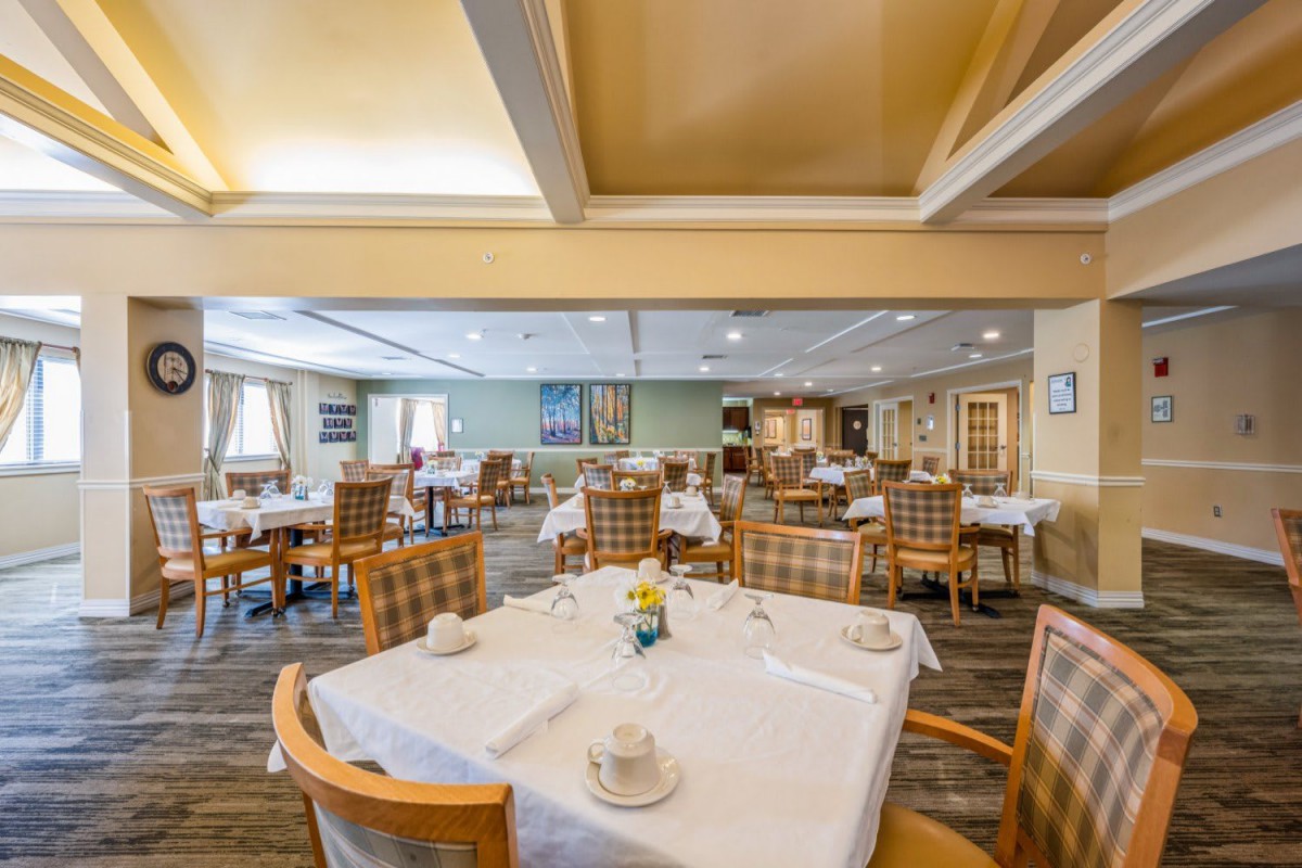 An empty restaurant dining area with neatly set tables and chairs.