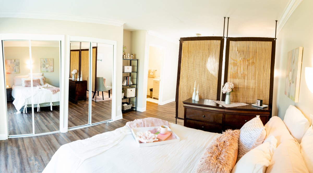 A cozy and stylish bedroom with a large wardrobe and mirrored sliding doors.