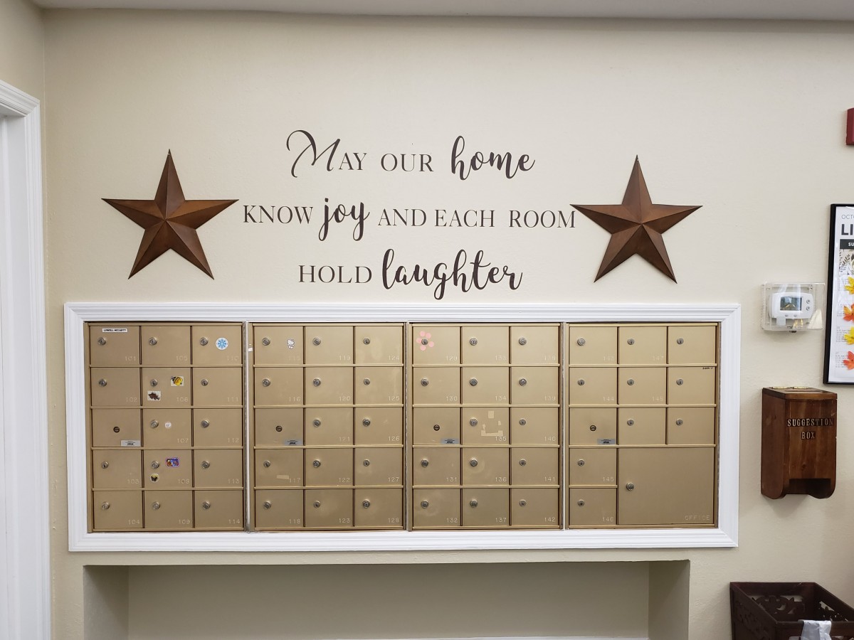 Decorative wall with mailboxes and a heartwarming quote.