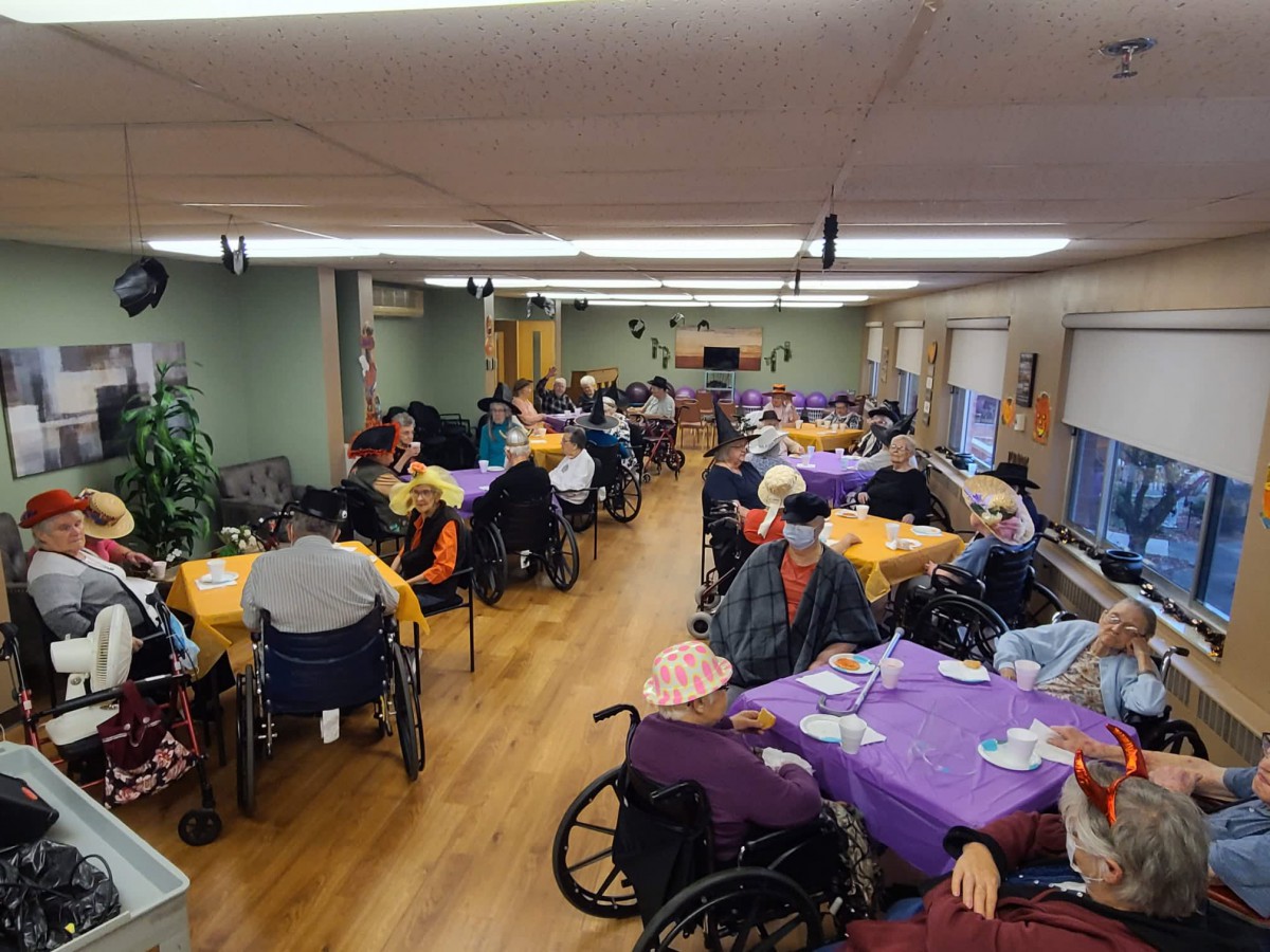Residents of a nursing home gather in the dining area for a communal meal.
