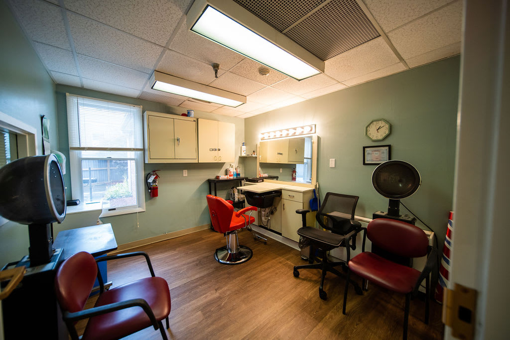 Cozy hair salon interior with seating and styling stations.