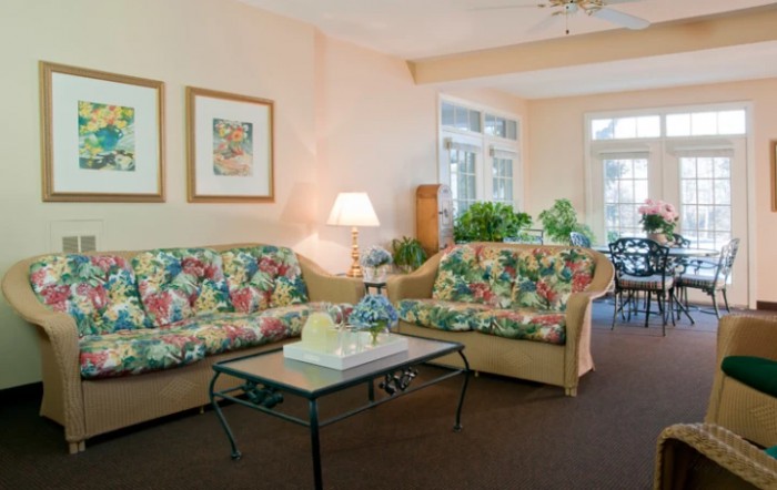 Cozy living room with floral couches and plenty of natural light.