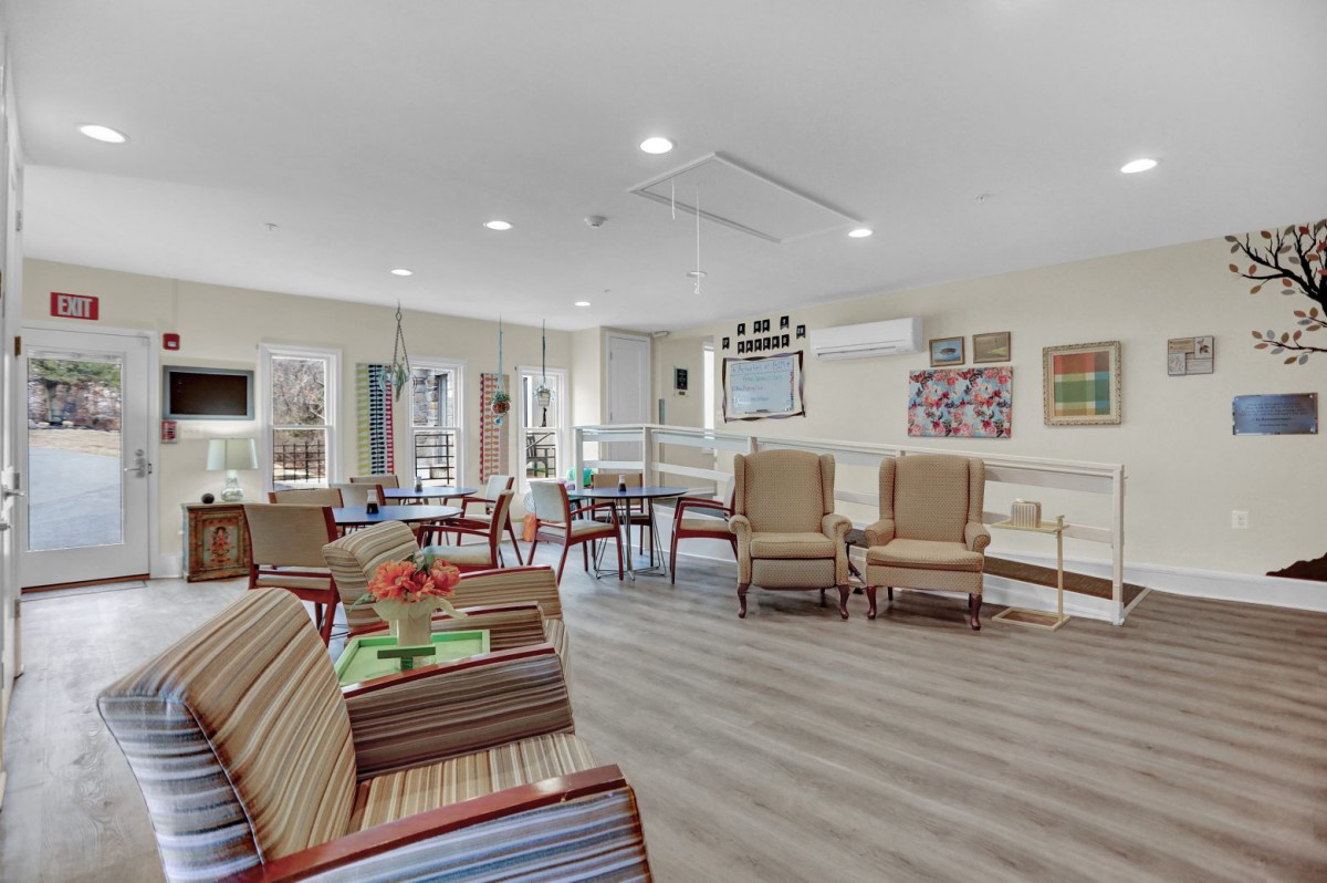 A bright and comfortable living room with multiple seating options, modern decor, and large windows.