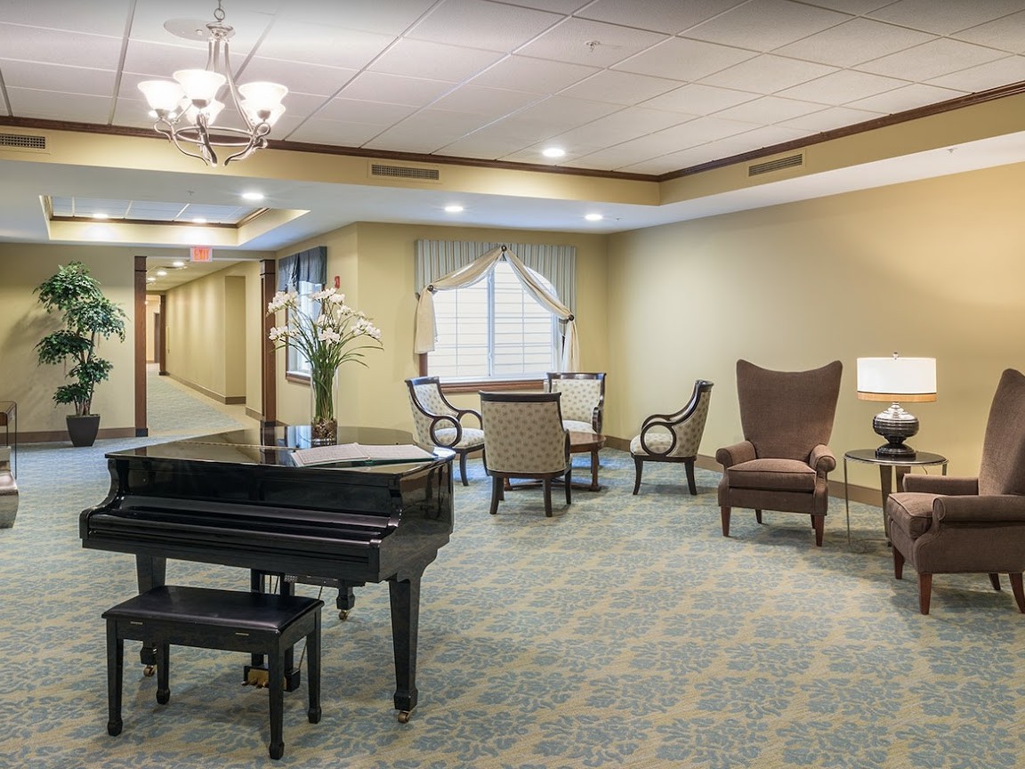 A sophisticated lobby featuring a grand piano and elegant seating arrangements.