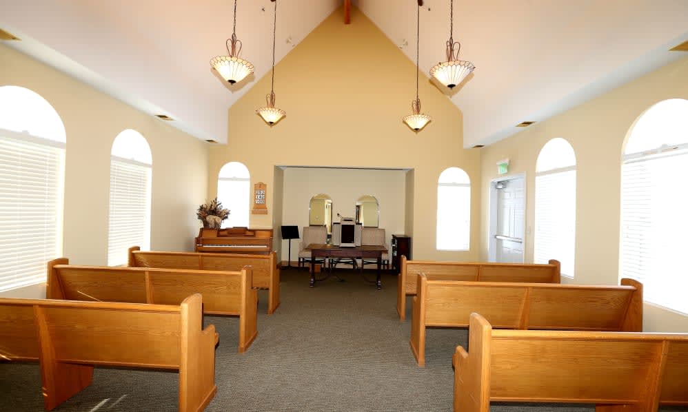 Interior view of a small chapel with wooden pews and altar.