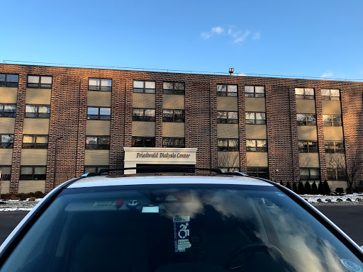 A car parked in front of a brick building under a clear blue sky.