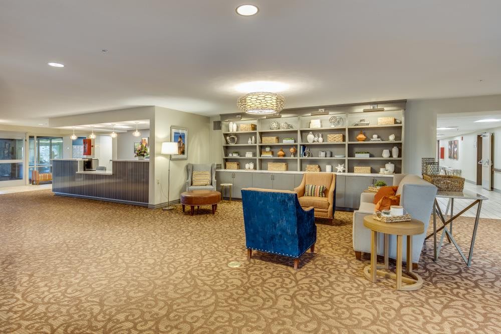 A welcoming hotel lobby with comfortable seating and a stylish bookshelf.
