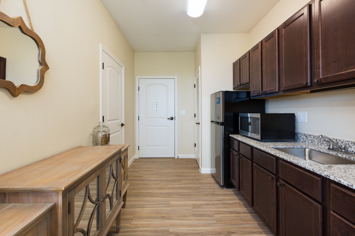 A modern kitchen with dark wood cabinets and stainless steel appliances.