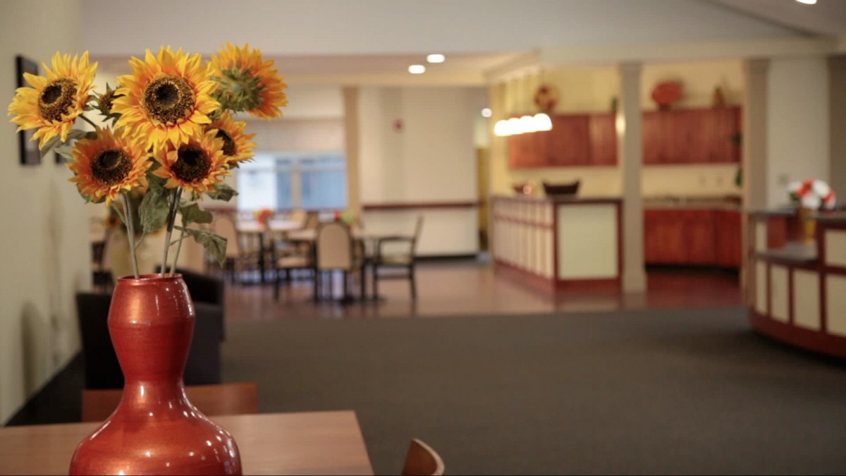 A cozy dining area with sunflowers in the foreground.