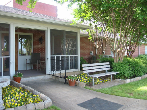 A welcoming front porch with a bench and blooming flowers, inviting relaxation.