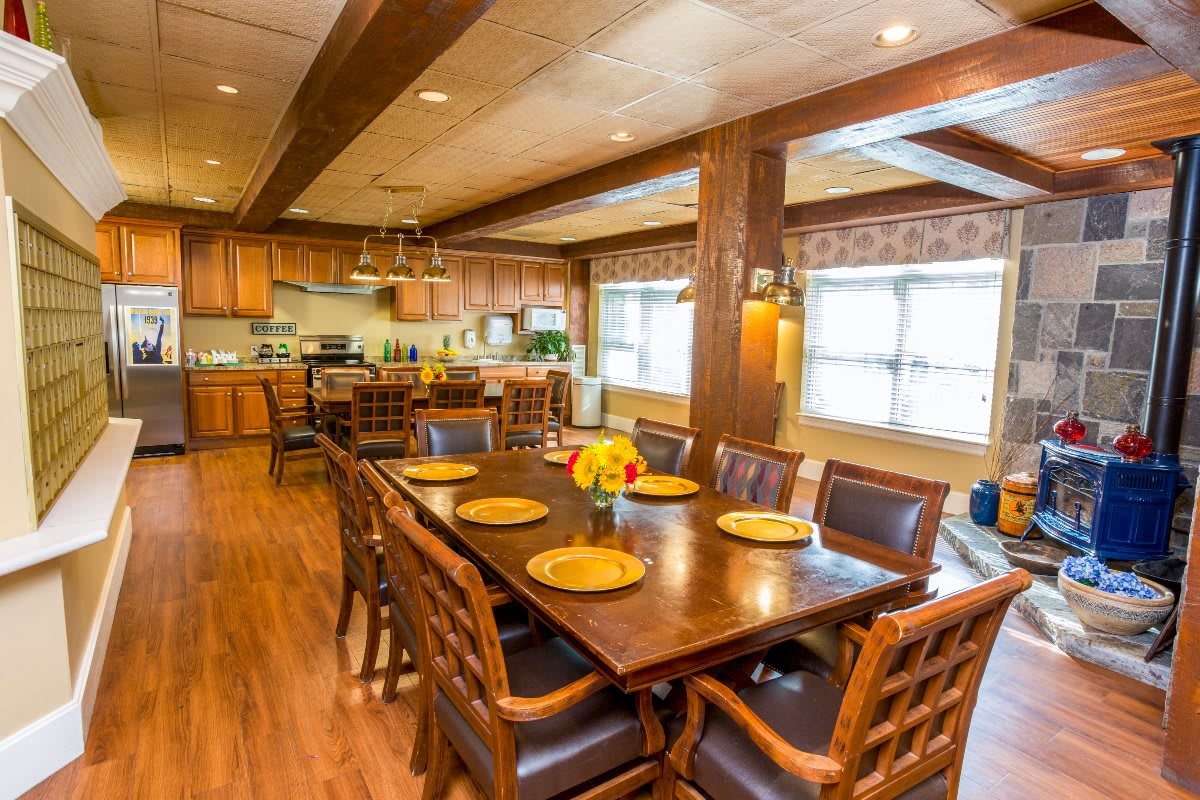 A cozy dining area connected to a kitchen, featuring wooden furniture and natural lighting.
