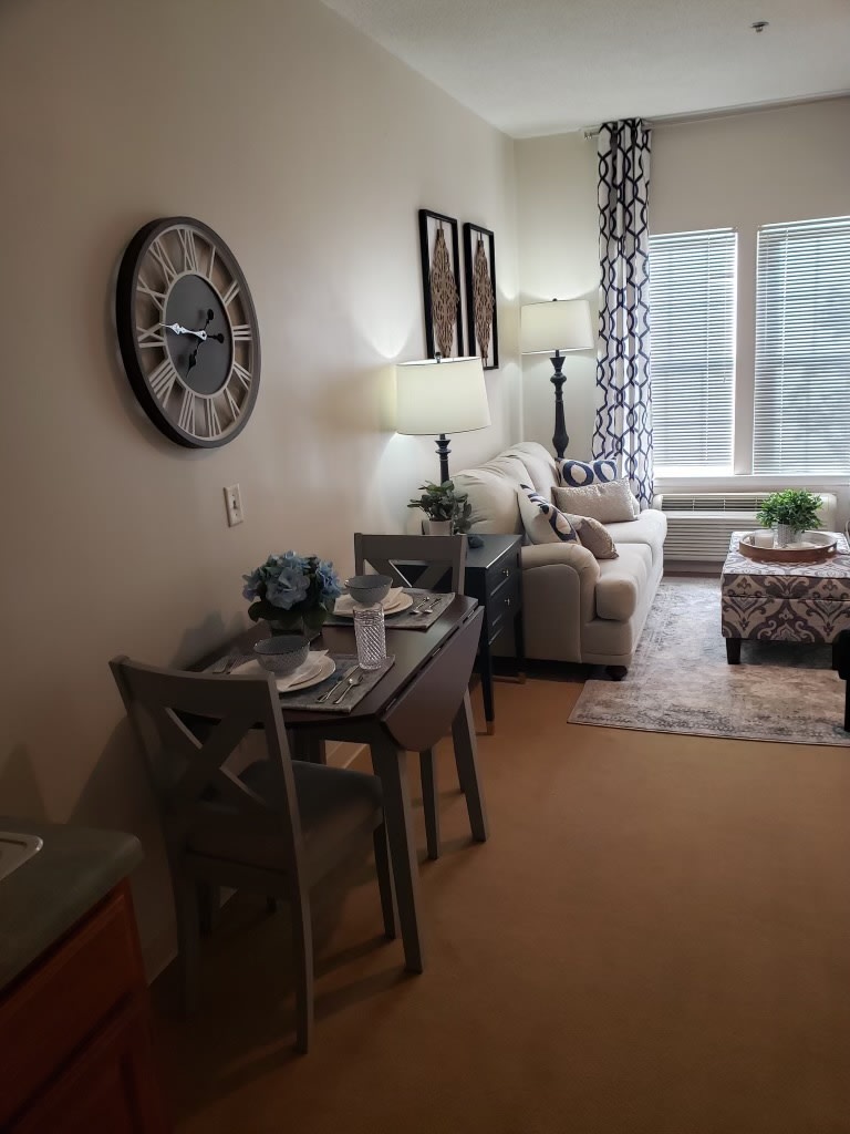 A cozy living room with a stylish sofa, dining table, and decorative elements.
