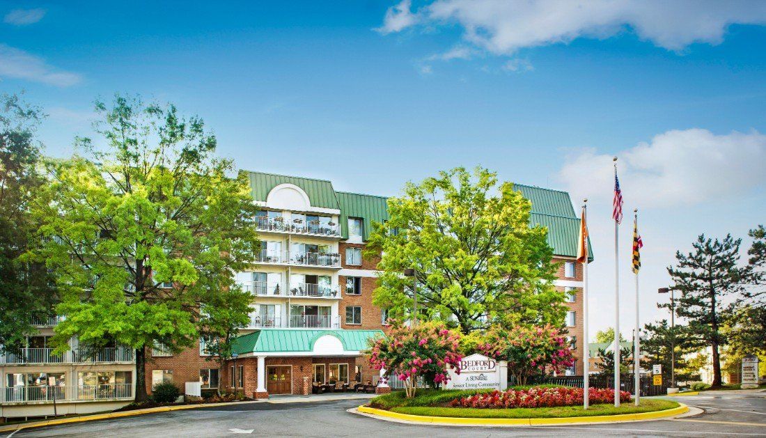 A hotel with a green roof surrounded by trees and well-maintained landscaping.