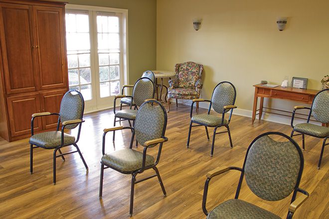 An empty room with chairs arranged for a meeting.