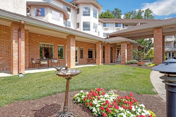 A well-maintained garden with colorful flowers in front of a multi-story residential building.