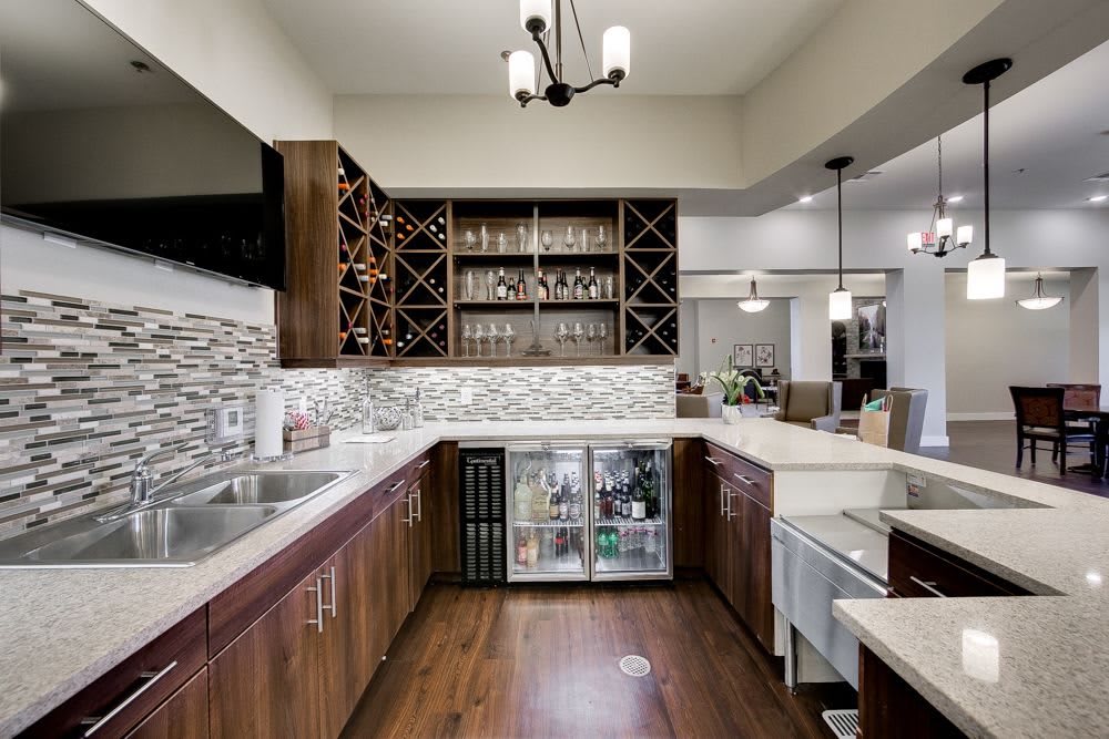 Modern kitchen with a wine rack and bar area featuring wood flooring and contemporary design.