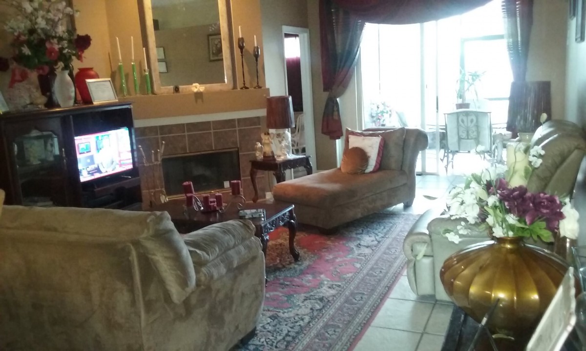 A cozy living room with a fireplace, sofas, and elegant decor.