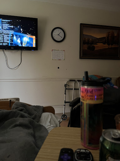 A cozy room featuring a television, clock, and a colorful beverage on the table.