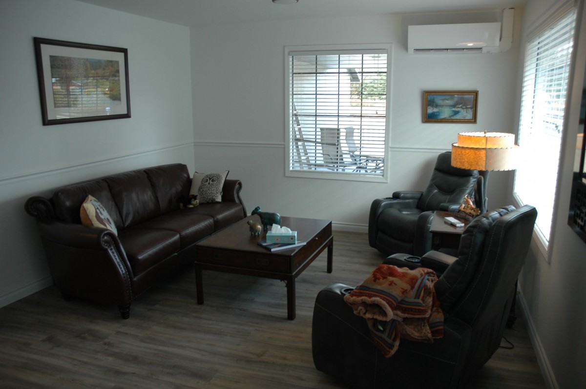 A cozy living room with a sofa, armchairs, and a coffee table arranged around a lamp.