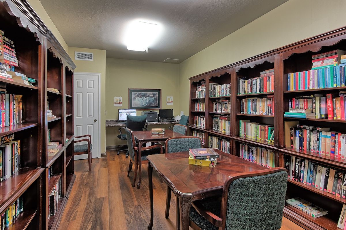 A cozy library with wooden tables and bookshelves lined with books.