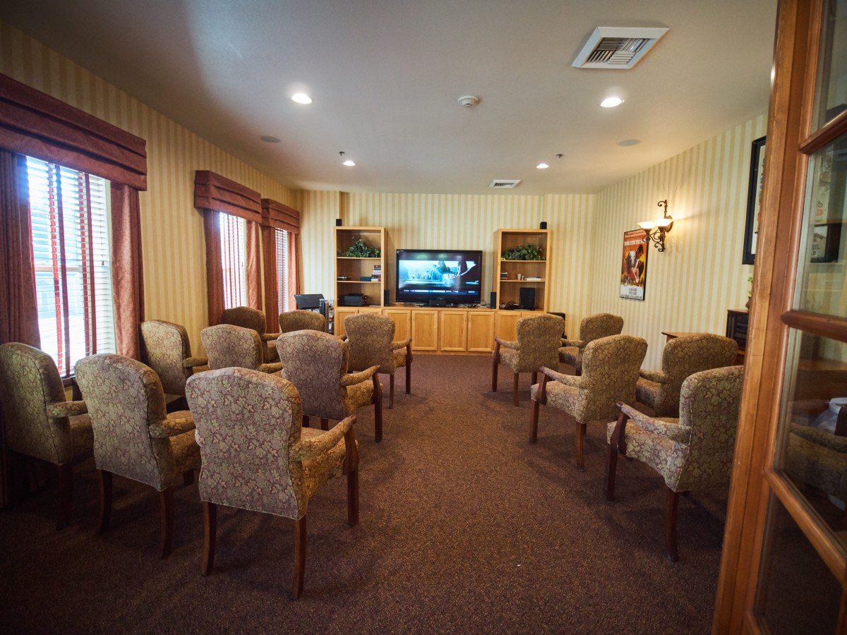 A small meeting room with arranged chairs facing a television.