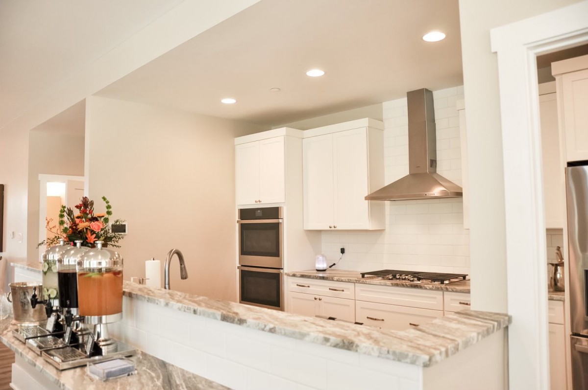 A modern kitchen with white cabinets and stainless steel appliances.