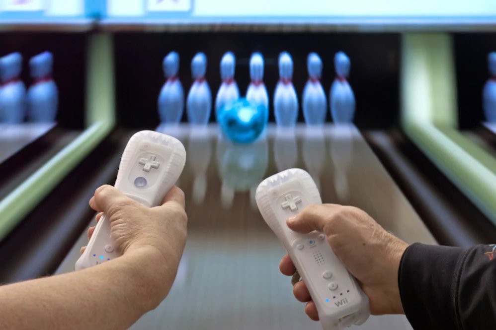 Playing a virtual bowling game using motion control remotes.