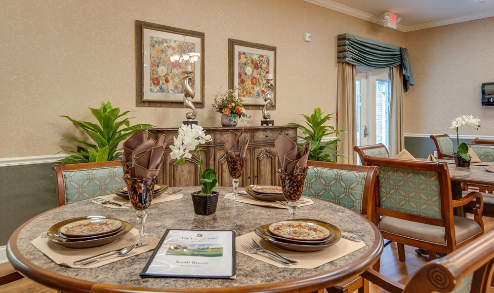 A beautifully set dining table with elegant decor and artwork in a cozy dining room setting.