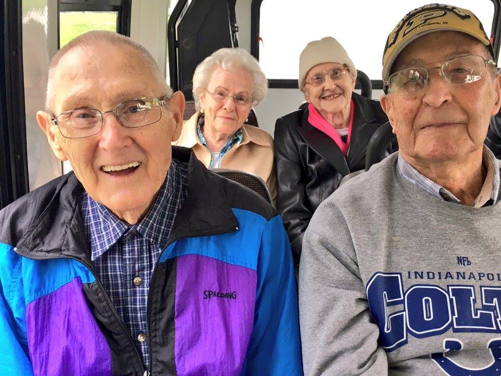 A group of seniors smiling and sitting together.