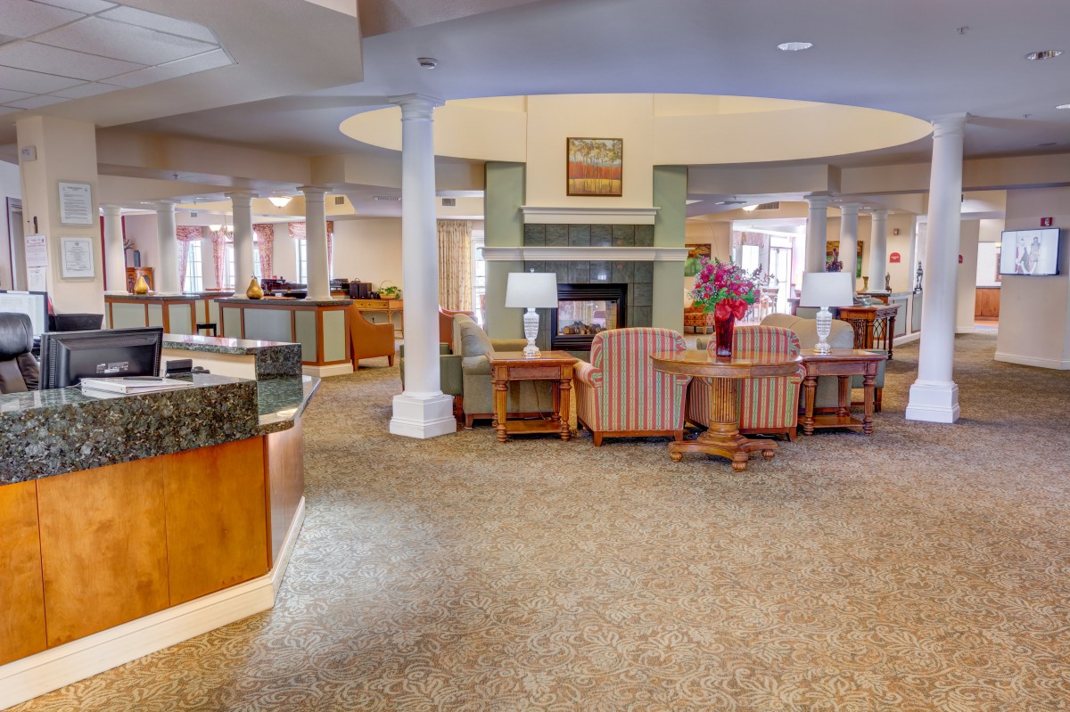 A spacious lobby interior featuring comfortable seating and a fireplace.