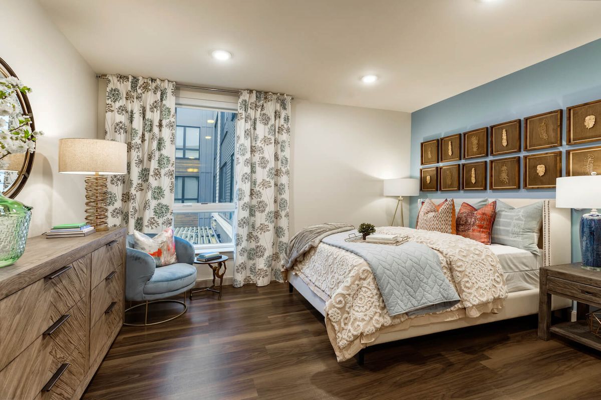 A modern and cozy bedroom featuring wooden floors, elegant furniture, and stylish decor.