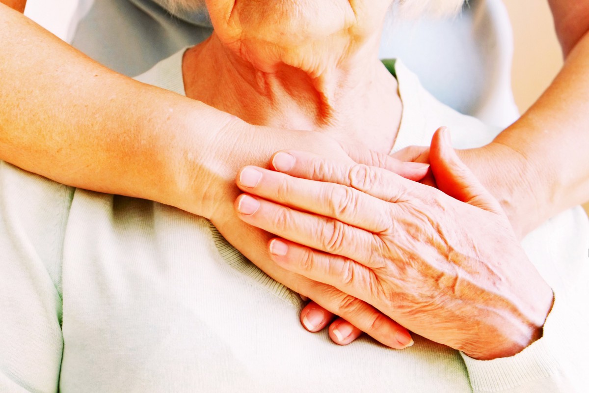 A comforting gesture with hands placed gently on the chest.