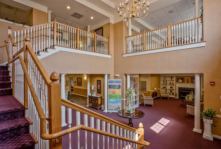 A spacious and elegant lobby with a grand staircase and chandelier.