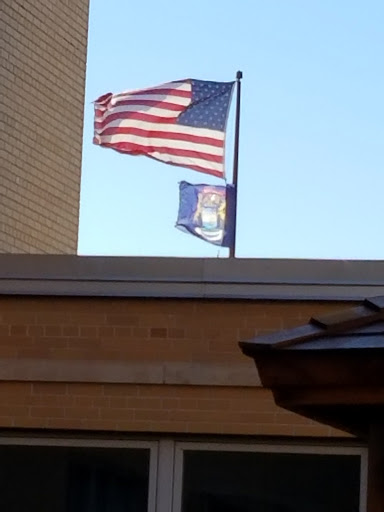 Flags of the United States and Michigan waving in the breeze.